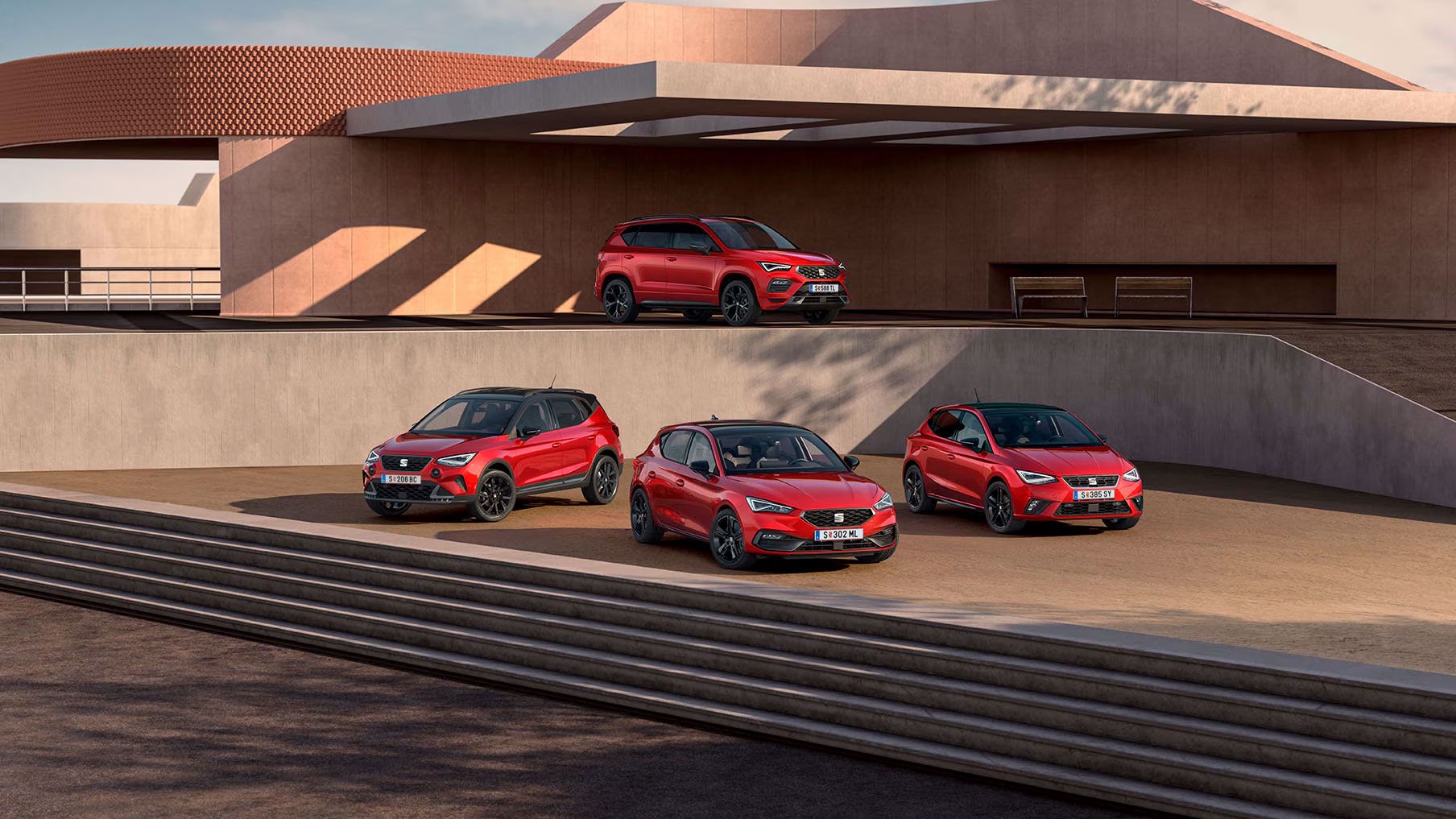 SEAT Black Edition Range shooting, sind vor einem zweistöckigen öffentlichen Gebäude mehrere Modelle zu sehen: Im unteren Bereich stehen der Arona, der Leon und der Ibiza, während auf der oberen Etage der Ateca positioniert ist