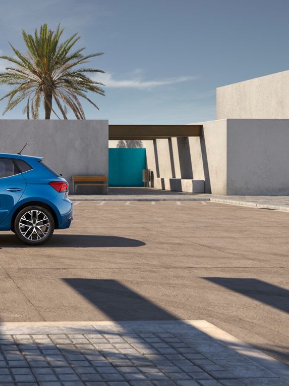 Ein blauer SEAT Ibiza präsentiert sich in seitlicher Ansicht, geparkt auf einem Parkplatz.