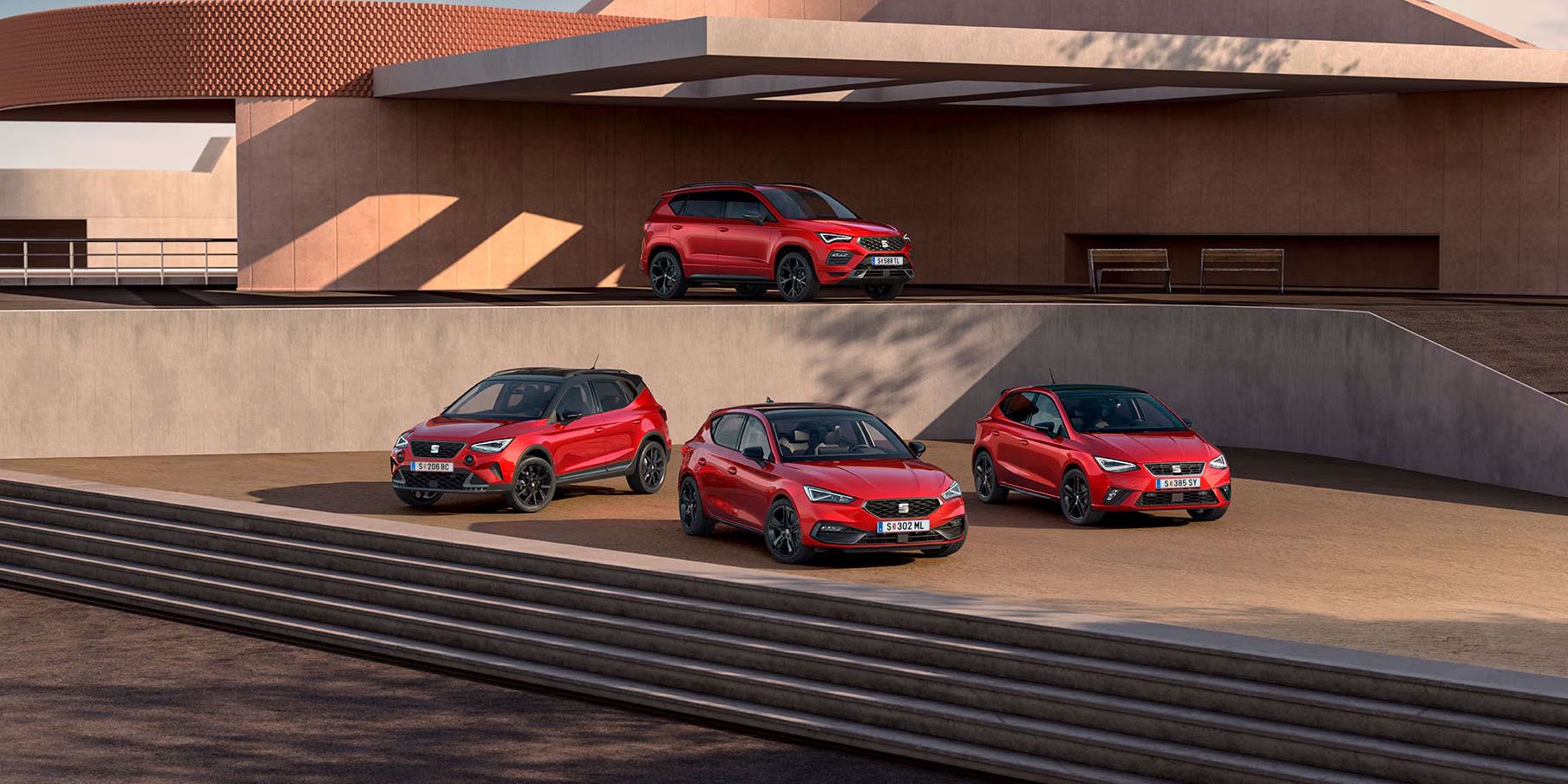 SEAT Black Edition Range shooting, sind vor einem zweistöckigen öffentlichen Gebäude mehrere Modelle zu sehen: Im unteren Bereich stehen der Arona, der Leon und der Ibiza, während auf der oberen Etage der Ateca positioniert ist